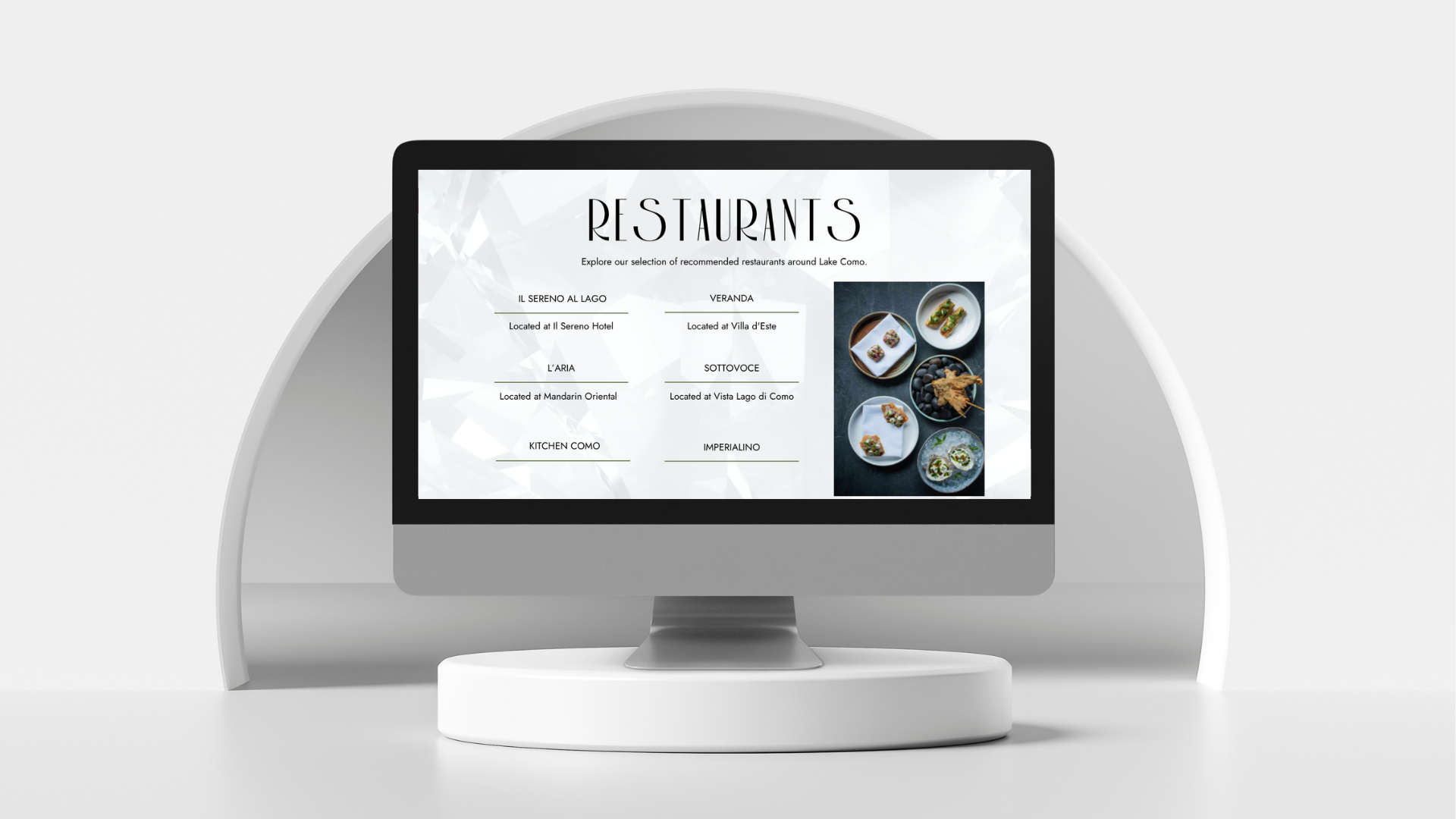 A computer monitor displays a minimalist, bespoke website for a restaurant listing with the heading "RESTAURANTS" and a selection of names. To the right, small images of plated dishes are shown on a modern white background.